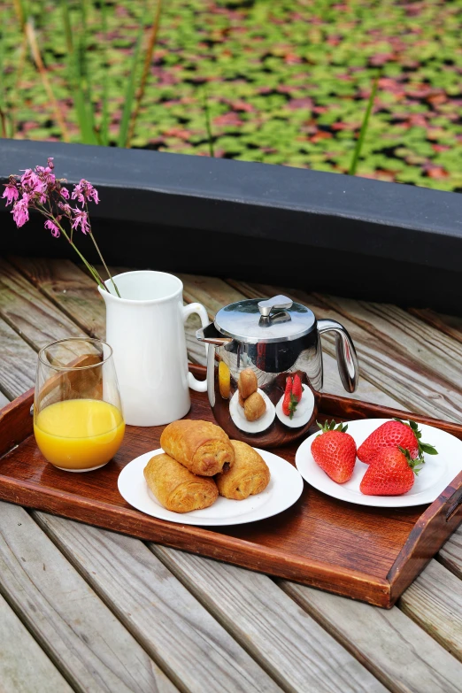 a tray holding drinks and pastries with strawberries