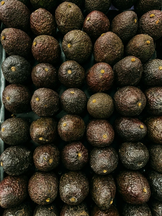 several bunches of avocados piled up together