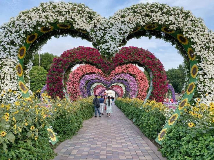 people standing outside a very pretty flower garden