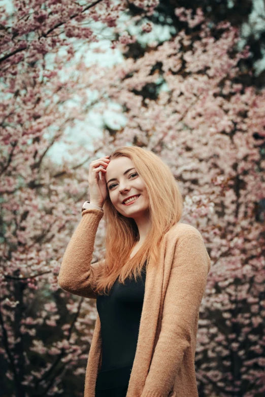 the young woman is posing by the pink flowers