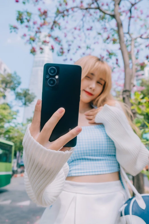 the girl poses with her phone to take a selfie