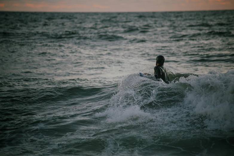 a surfer riding a small wave in the ocean