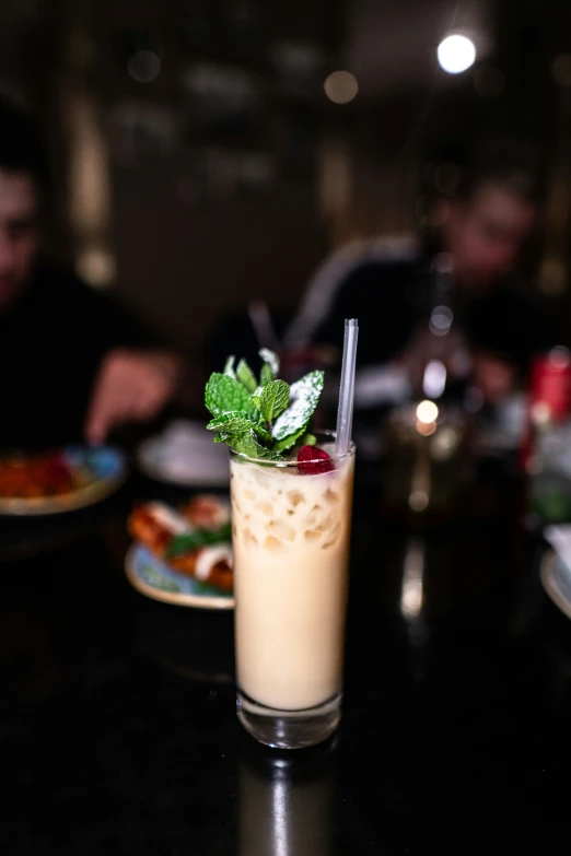 a drink sitting on top of a table next to plates