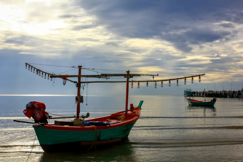 two small boats are on the water in front of pier