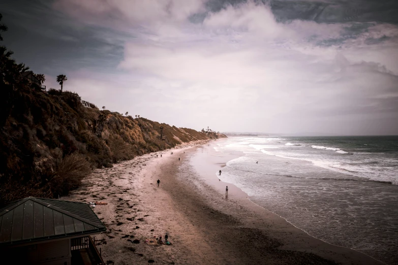 people are standing in the ocean and looking at the beach