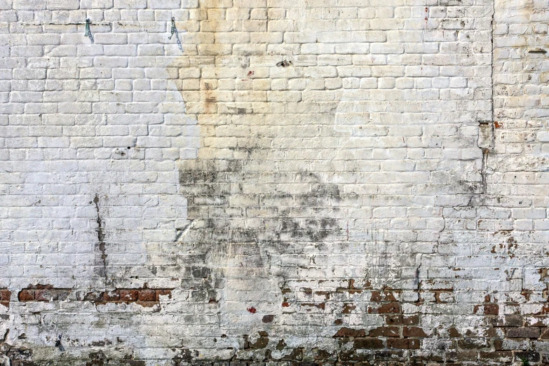 an old painted brick wall with lots of dark spots