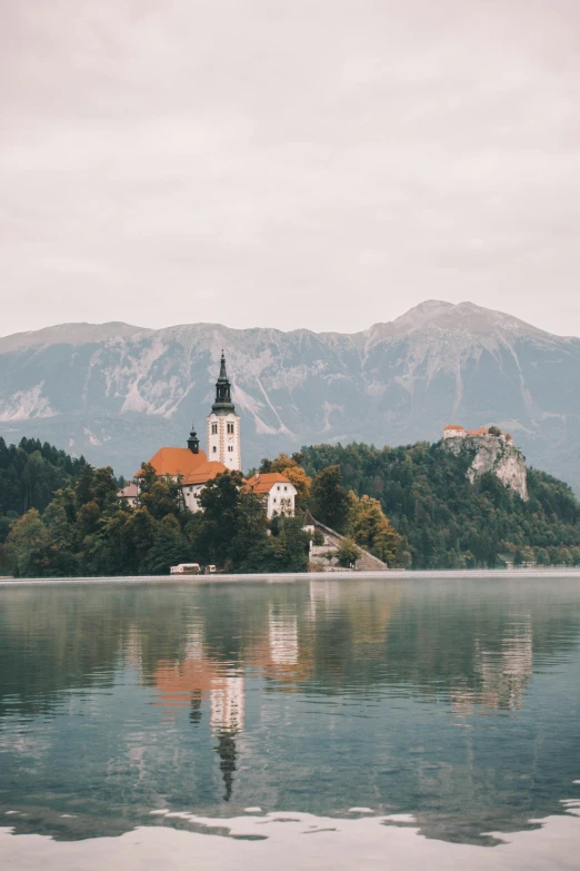 a scenic church with a red roof reflected in the water