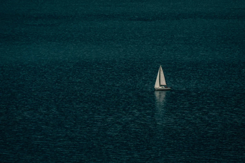 a small sail boat is floating in a large body of water