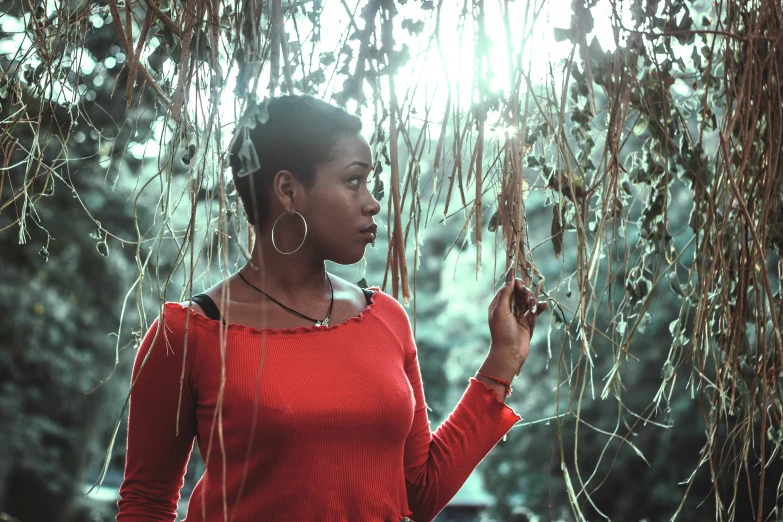 the woman wearing a red sweater is holding an animal