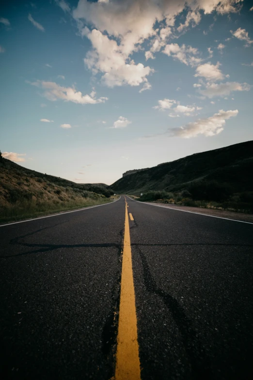 the yellow line is painted on a long empty road