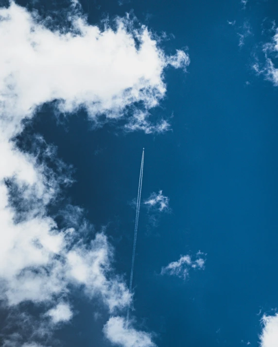 an airplane flying in the sky with a contrail