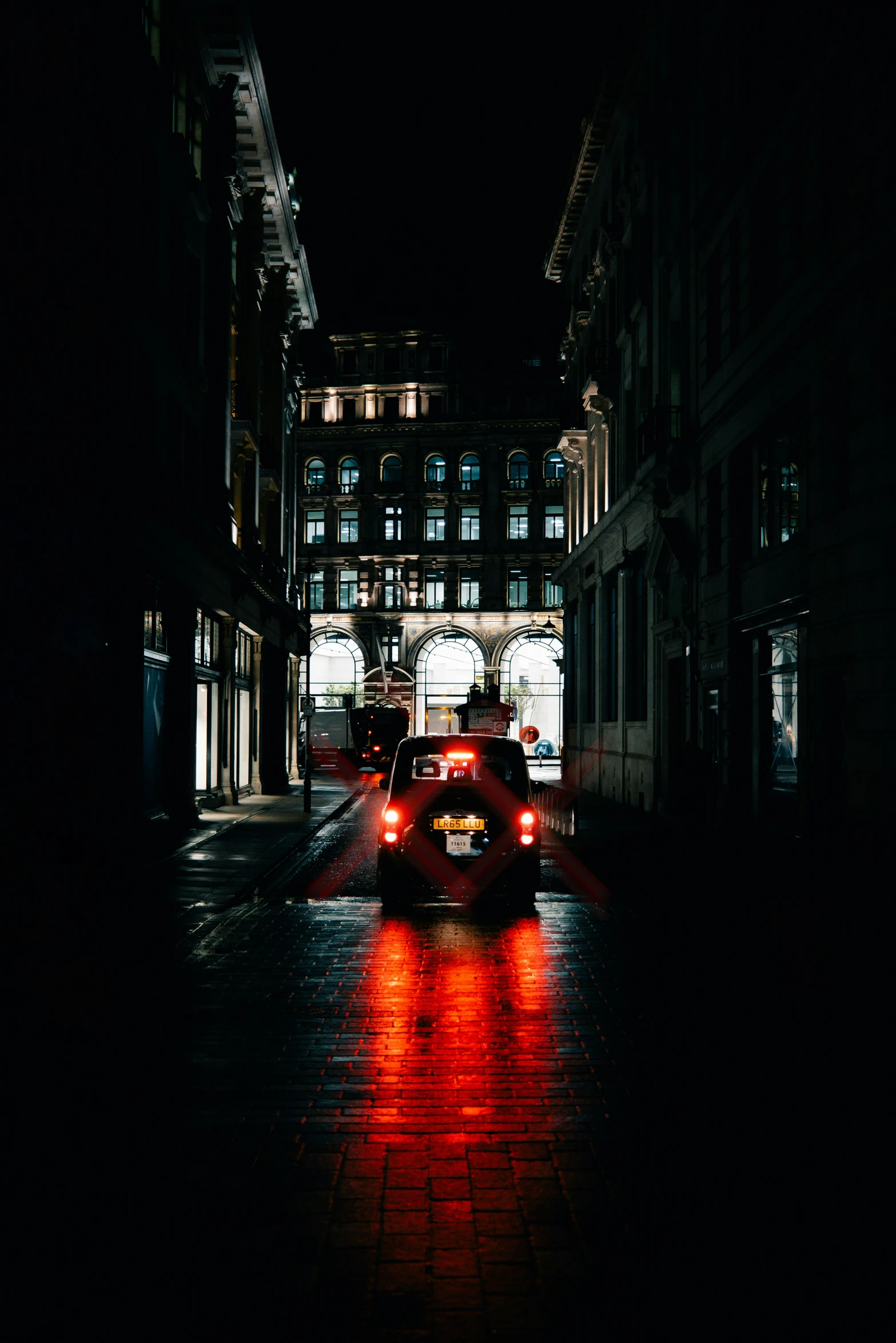 cars driving down a rainy street in a city