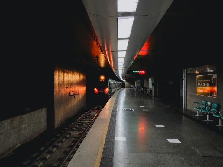 a subway station that is dark with lights in it