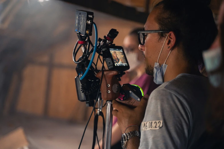 a person with eye glasses operating a camera