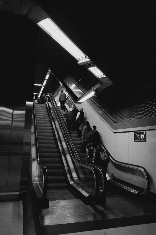 an escalator in a subway terminal with many people