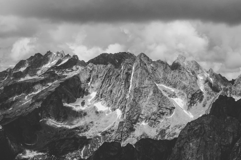 there are clouds above mountains that are black and white