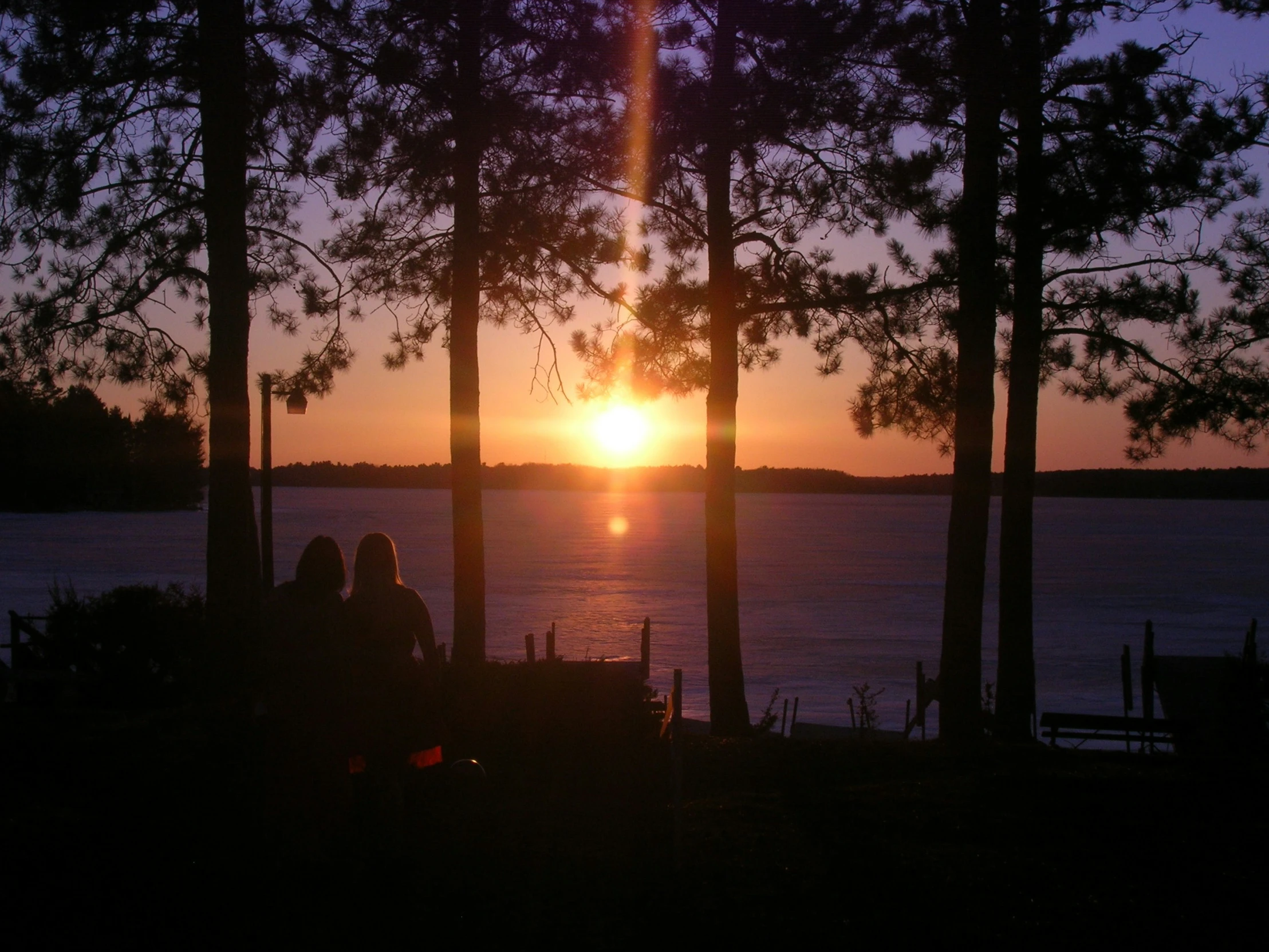 a couple sits watching the sunset with each other