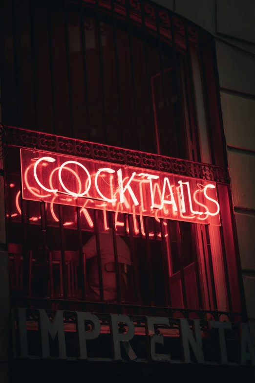 neon text written in red light that reads cocktails