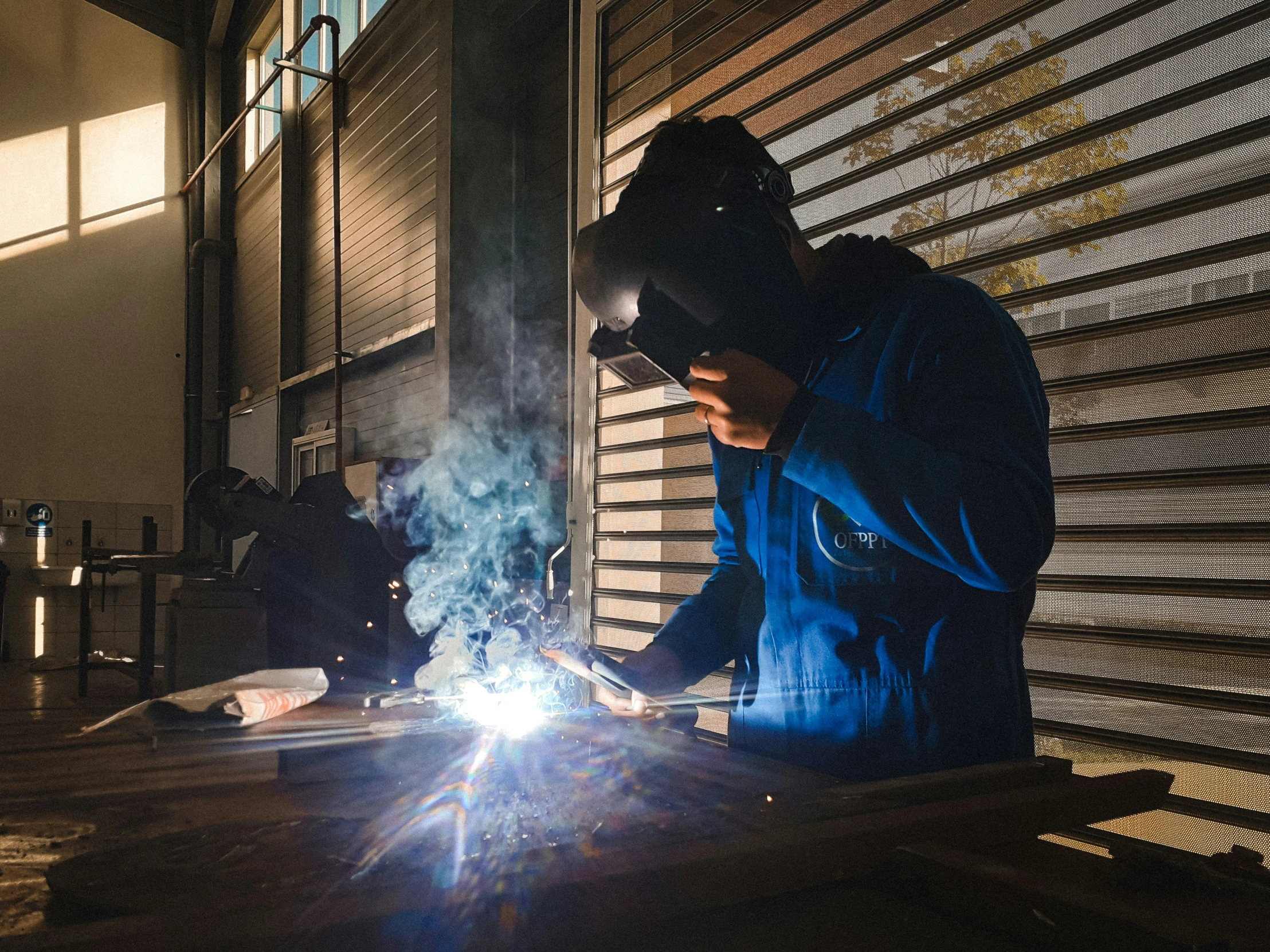 two men in dark work on some steel pipes