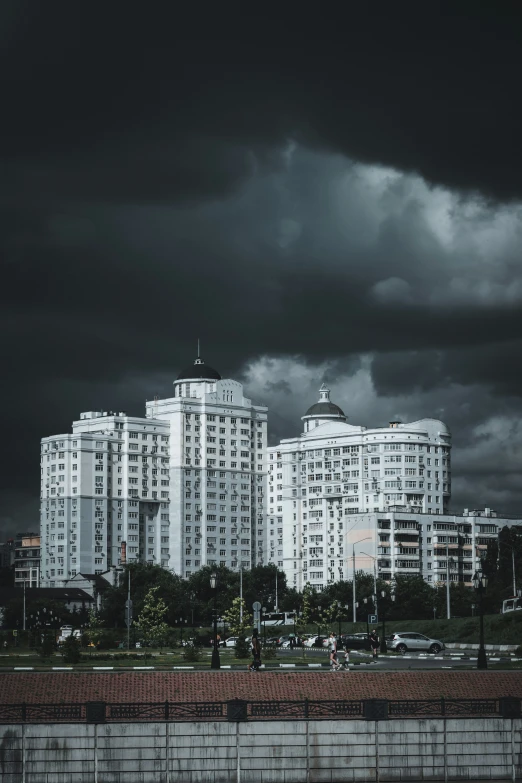 there is a building that is white with lots of dark clouds