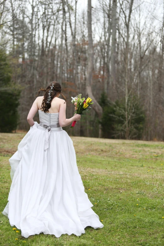 a beautiful woman in a dress holding flowers in her hand