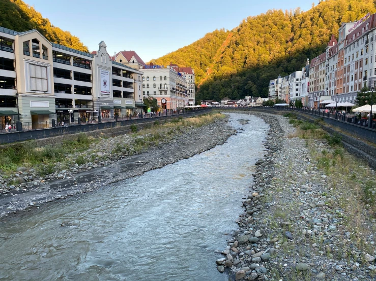 a river runs through a town next to the train tracks