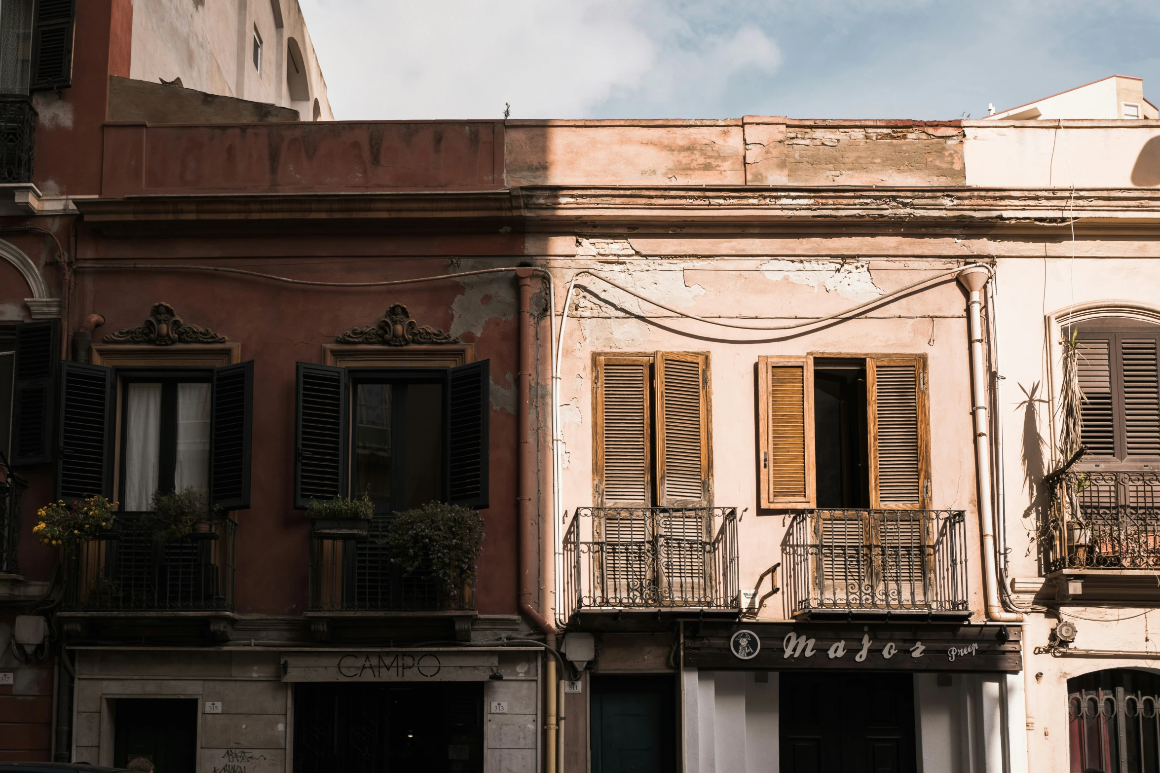 a building with windows and shutters is shown on a cloudy day