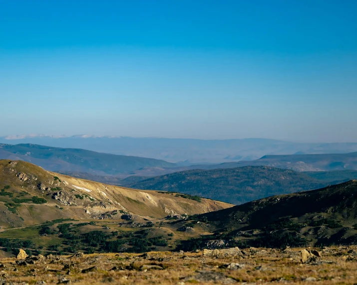 a mountain is in the background with rocks and grass