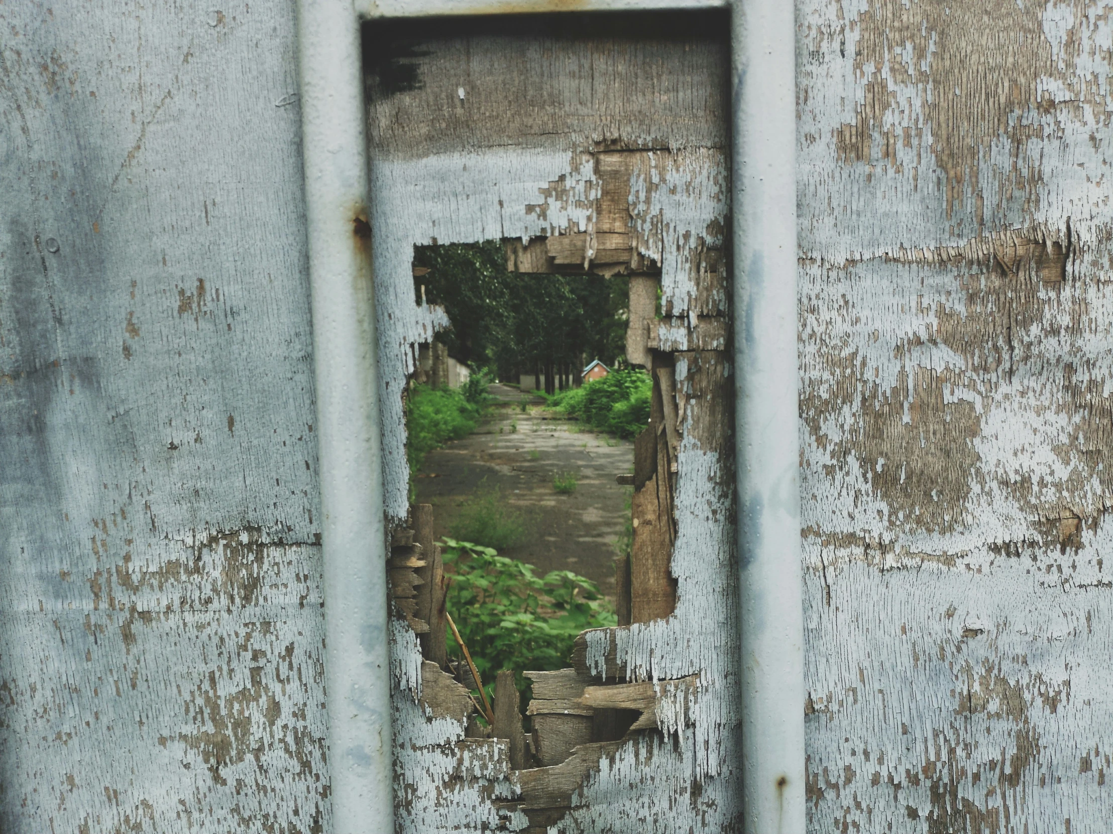 a window into a building that has rusted paint and other debris