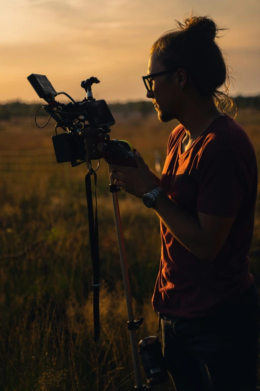 a woman holding a camera on a tripod