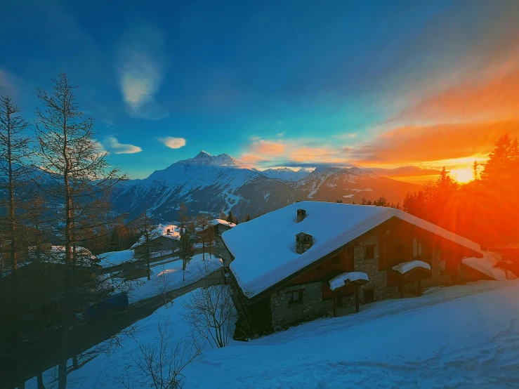 the sun is setting behind a mountain covered in snow