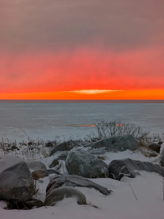 sunset behind rocks on the beach near the ocean