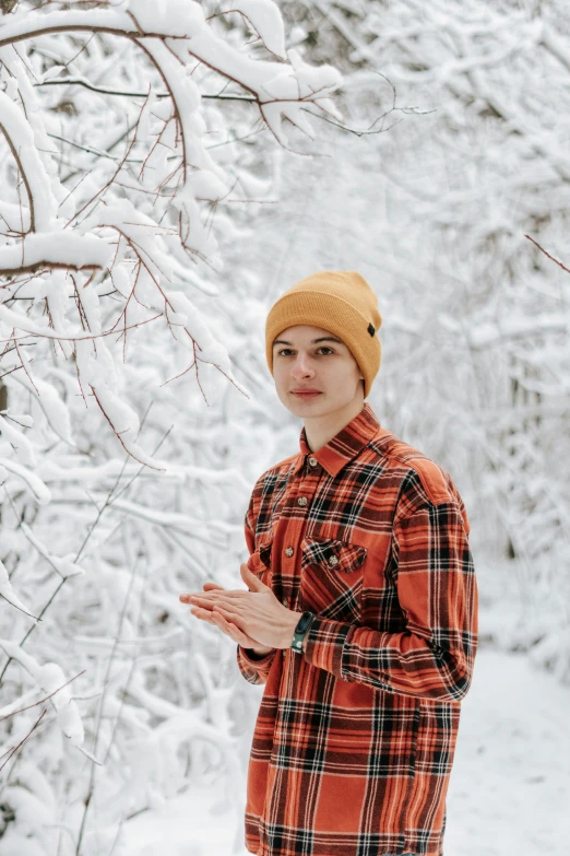 a man in a plaid coat standing next to some snow