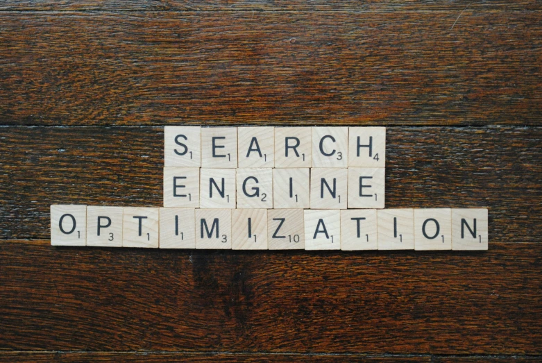 scrabbled letters spelling search engine optimization on top of a wood surface