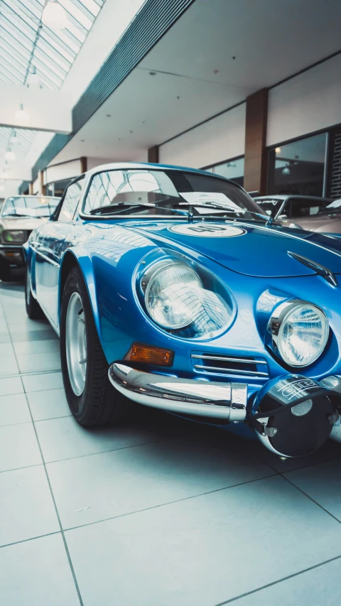 three classic sports cars parked inside of a building