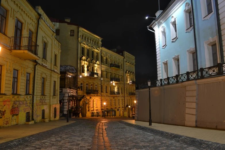 a cobblestone street with an assortment of old buildings along it