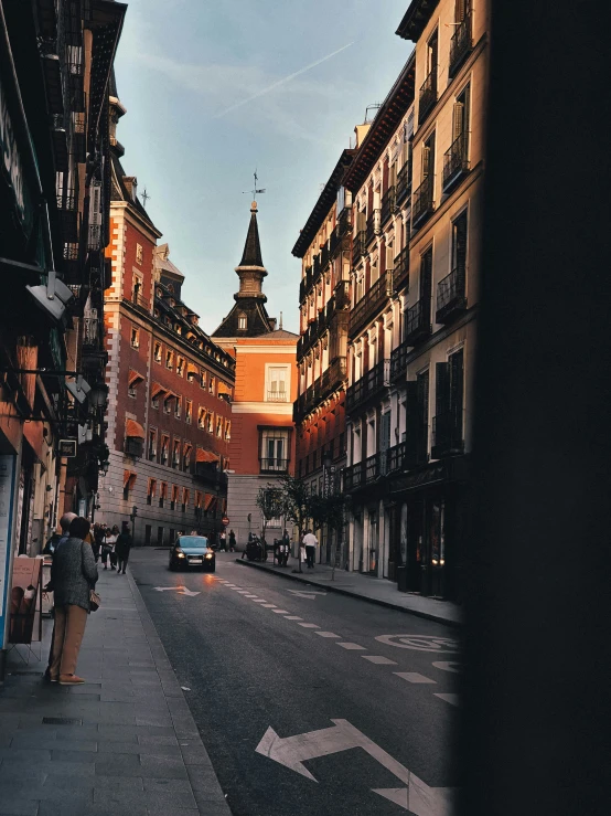 looking down an empty street with cars and buildings in the background