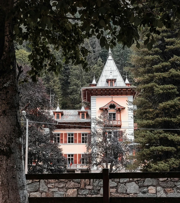 a large house surrounded by trees and a gate