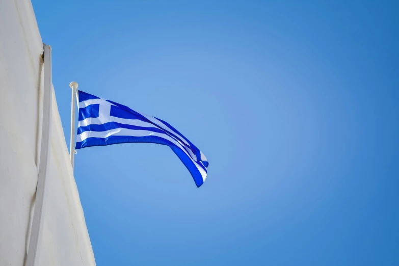 the greek flag is flying on a clear day