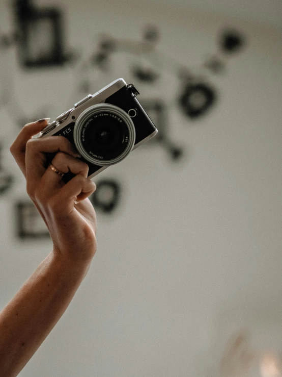 someone is holding a camera in front of the wall