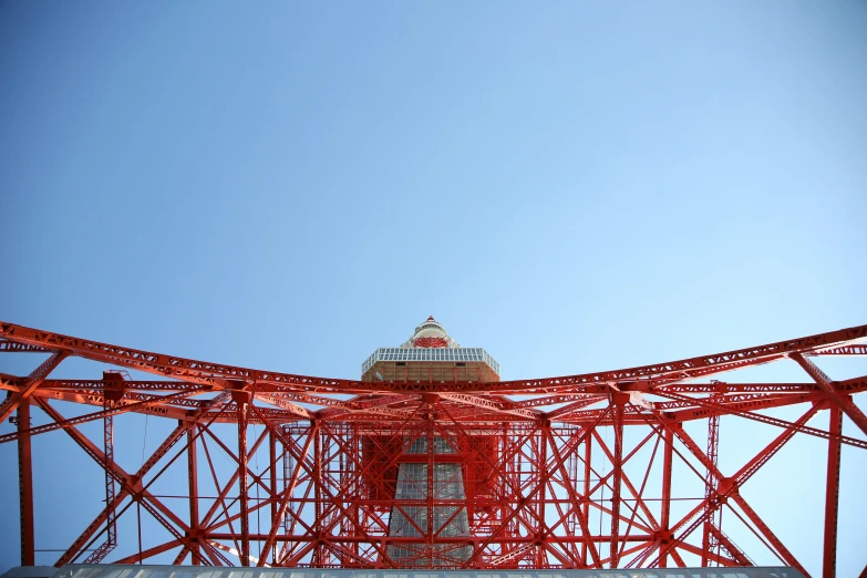 a red tower and cross above a blue sky