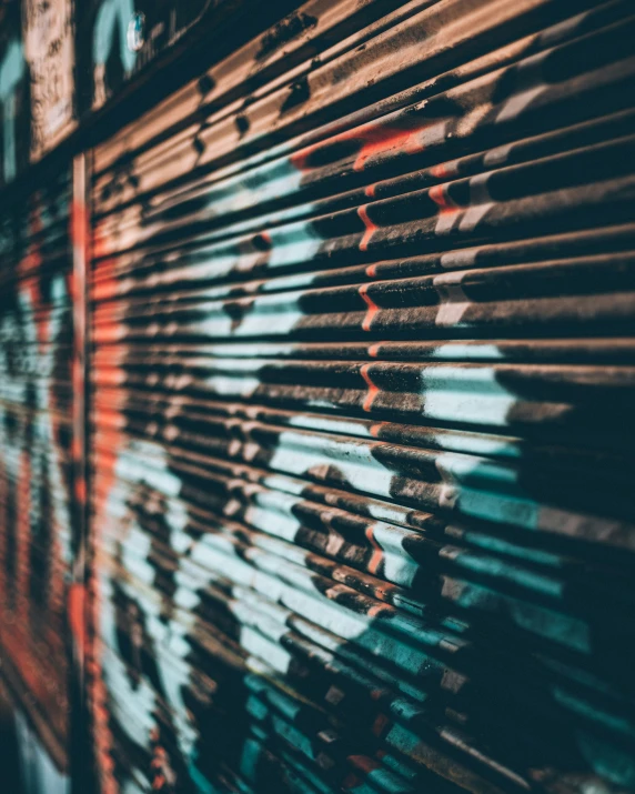 a metal frame with graffiti and window blinds on the side