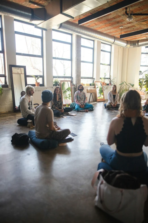 people are sitting in the middle of a room doing yoga