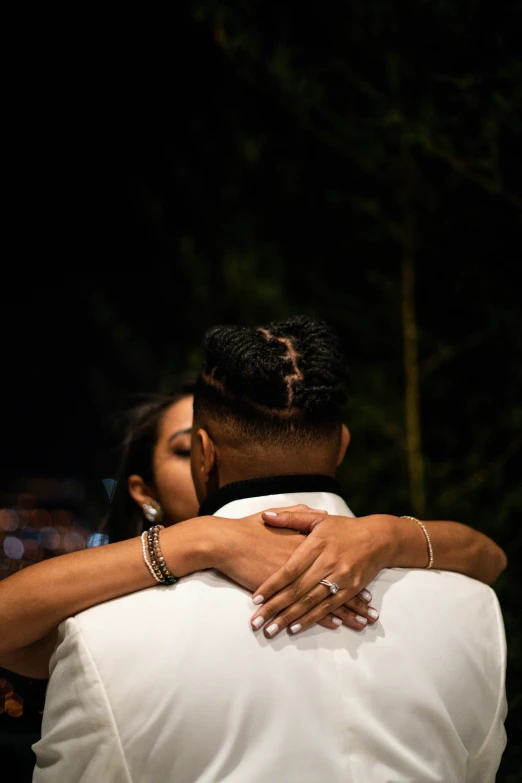 a couple hugging each other in a forest