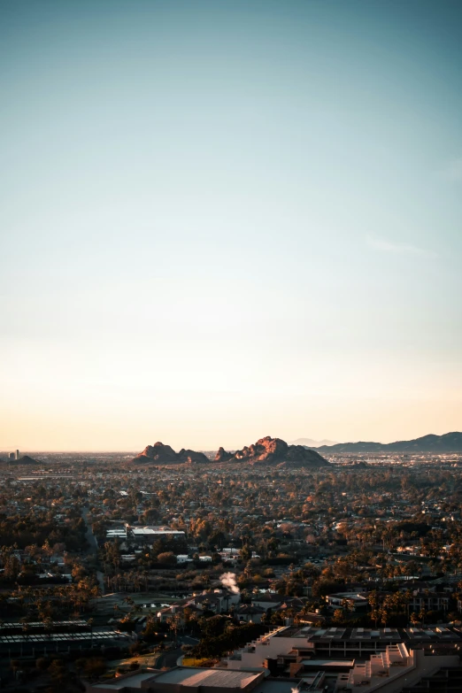 an airplane flying over a city skyline with mountains