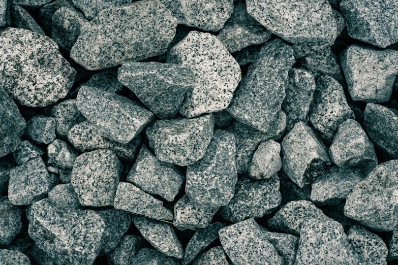 a pile of black rocks covered in grey gravel