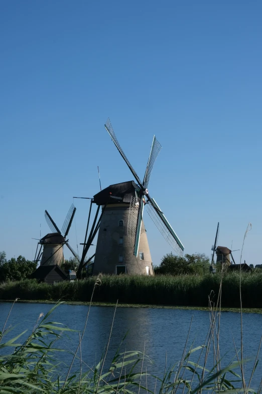 a windmill is sitting next to a small body of water