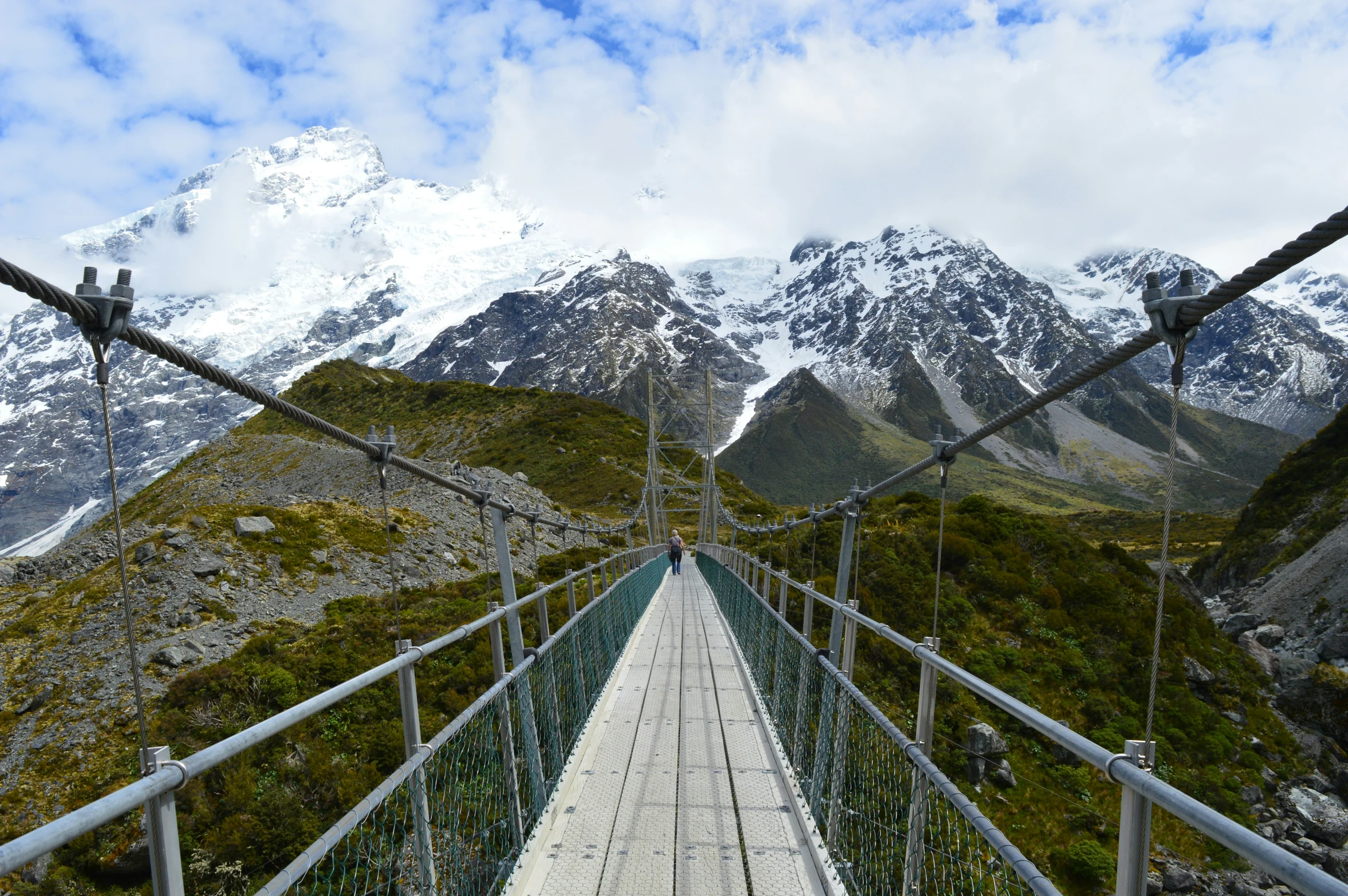 a suspended walkway surrounded by a mountain range