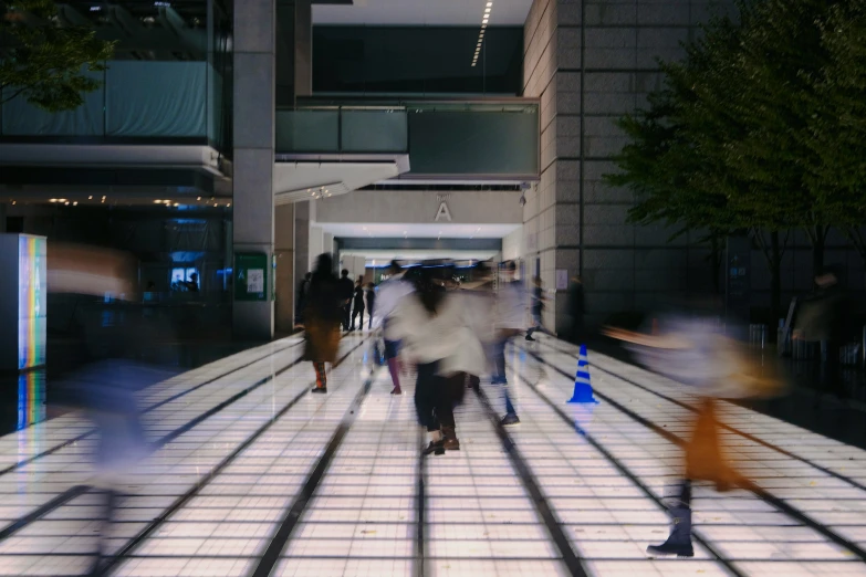 people walking down an empty building and some moving