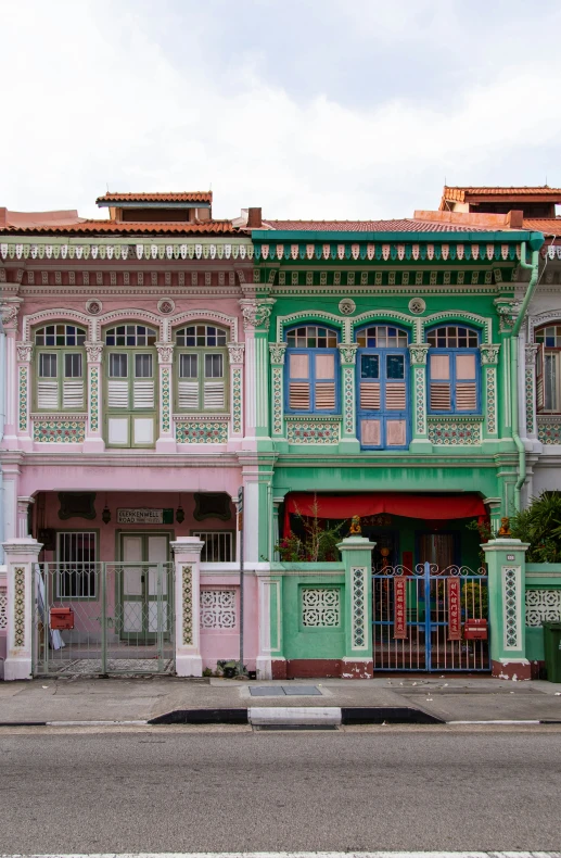 a green, pink and white building on a street corner